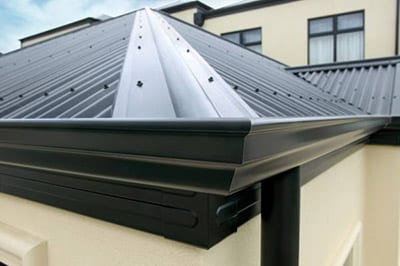 A gutter installed on the corner of a metal roof by Alpine Roofing Construction
