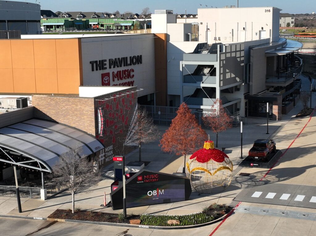 The Pavilion music venue with a giant ornament decoration and empty parking lot on a sunny day.